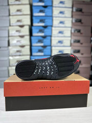 Underside view of the sneaker showing the black patterned outsole and red heel accent.