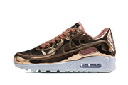 Side view of a rose-gold-toned Nike Air Max 90 QS sneaker with dusty-rose laces and a white sole.