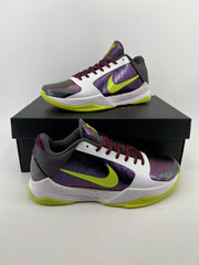 Pair of low-top Nike Kobe basketball shoes in white, iridescent purple, dark gray, and volt green.