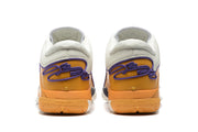 Rear view of the sneakers showing gold-orange heel panels, purple detailing, and padded collars.