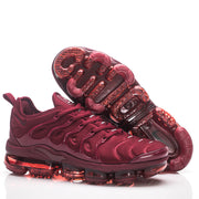 Burgundy Nike sneakers viewed from the side and underside, showing the sole tread.