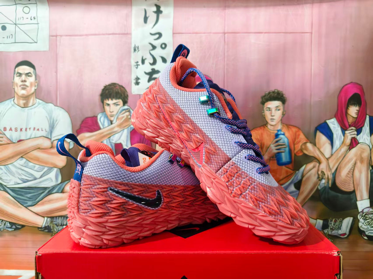 Pair of pink and lavender Nike basketball shoes shown at an angle on a red box
