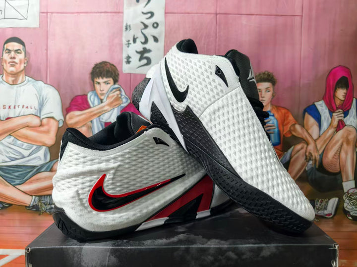 White, black, and red Nike LeBron basketball shoes shown from the side and sole.