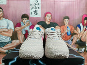 Front view of light pink basketball shoes with lace-up closures and textured uppers.