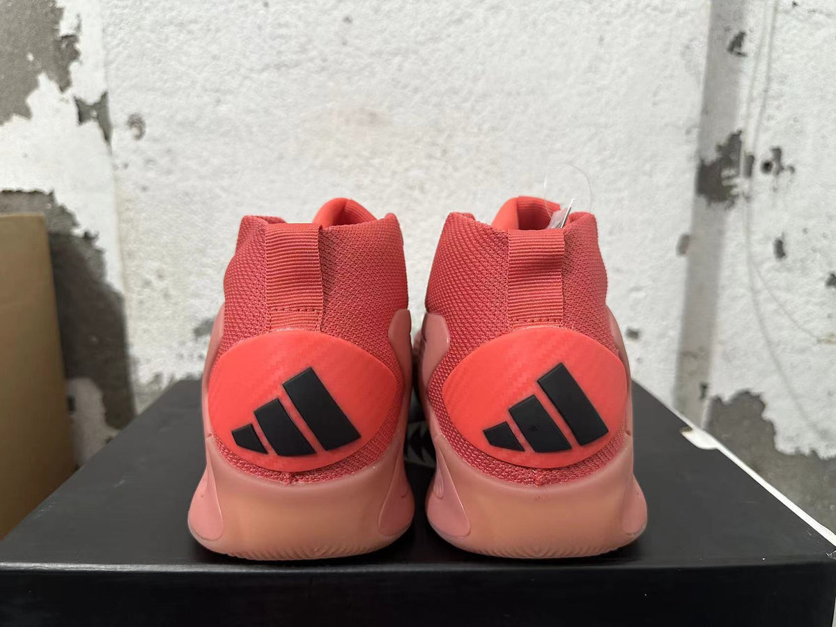 Rear view of pink Adidas mid-top sneakers with black heel logos.