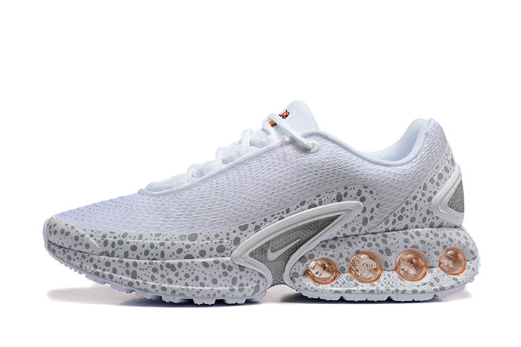 Side view of white and grey spotted Nike Air Max DN SE PRM sneakers with amber-toned heel elements.
