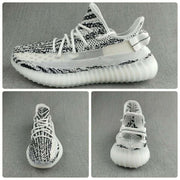 Collage presenting side, top, and front views of the black-and-white knit sneaker.