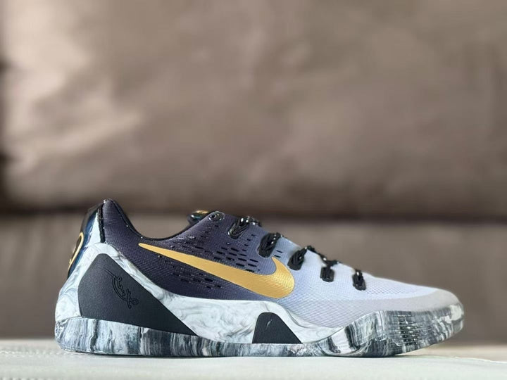 Side view of white Nike Kobe 9 GiGi sneakers with gold Swoosh branding, dark upper panels, and a gray marbled outsole.