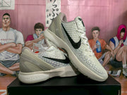 Angled view of the white and black basketball sneakers highlighting the textured upper, side branding, and layered heel structure.