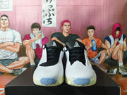 Front view of a pair of white basketball shoes with black laces and blue toe accents