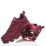 Pair of burgundy Nike sneakers arranged to show the upper, heel, and segmented translucent soles.