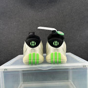 Rear view of the pair showing black collars, green heel emblems, and bright green outsole accents.
