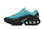 Side profile of a turquoise and black Nike Air Max DN sneaker with circular heel elements.