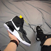 Angled side view highlighting the white Swoosh, elephant-print panel, layered black-and-white midsole, and heel cushioning window.