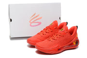 Red sneaker pair displayed in front of a branded shoebox.