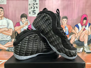 Angled view of a pair of black basketball sneakers showing the patterned uppers and translucent soles.