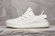 Side profile of a white Yeezy 350 V2 sneaker with a translucent ribbed sole.