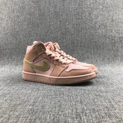 Front three-quarter view of the pink and olive Jordan sneaker showing the perforated toe and padded collar.