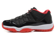 Single side profile showing the black upper, glossy toe and side panel, white midsole, and red outsole.