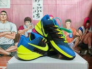Angled side view showing the blue, black, and yellow color blocking, side Swoosh, and orange lace details.