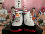 Pair of white, black, and red high-top Nike basketball sneakers shown from the front.