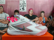 Side view of a white and pale pink Nike basketball shoe with lavender laces and a metallic-looking swoosh
