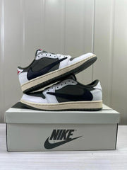 Pair of low-top sneakers in dark olive, white, and black, shown on a shoe box.
