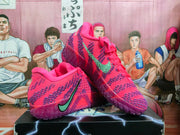 Angled view of the pink and purple Nike sneakers showing the side swoosh, textured upper, geometric outsole tread, and graphic shoebox.