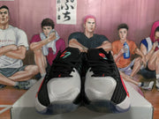 Front view of a pair of black basketball sneakers showing white toe panels, black laces, and red accents.
