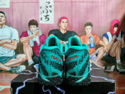 Rear view of the teal sneakers showing black patterned heels, black outsoles and red “TWELVE” lettering.