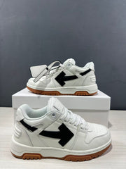Close product view of the white sneakers with black arrows, perforated toe boxes, and hanging tags.