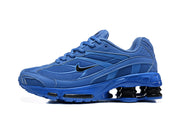 Side view of blue Nike Shox Ride 2 sneakers with mesh panels, black Swoosh, and heel cushioning columns.