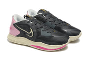 Angled view of charcoal and pink Nike Kyrie shoes