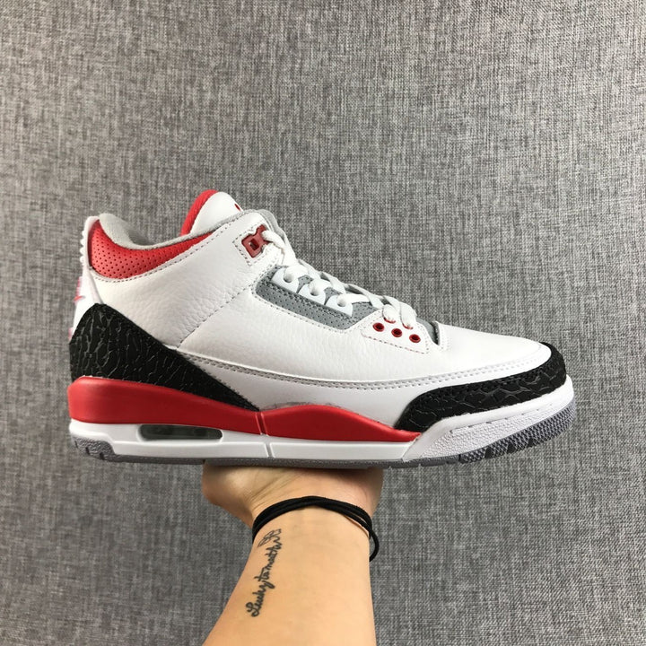 Side view of a white, red, and black Jordan Air Jordan 3 sneaker.