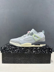 Single side profile of the Jordan Spizike Low sneaker on a speckled shoe box, showing its grey upper, pale green support panel, and cream midsole.