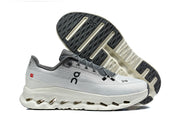White and grey On running shoe shown in side view with outsole visible.