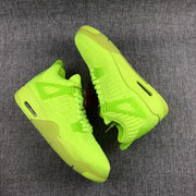 Pair of fluorescent green Jordan Air Jordan 4 sneakers shown from above on a gray fabric surface.