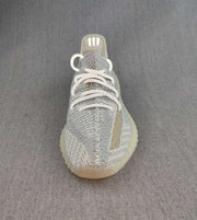 Front three-quarter view showing the patterned knit toe, reflective-looking laces, and side stripe.