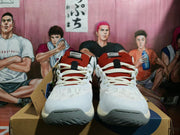 Front view of white ASICS basketball shoes with rust-red tongues and gray outsoles