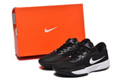 Black and white Nike sneakers displayed beside an orange Nike shoebox.