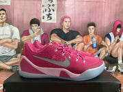 Side view of pink basketball shoes with contrasting side logo, lace-up closure, and light-colored sole.