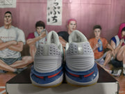 Rear view of white and blue Nike sneakers showing padded collars, textured heel panels and layered blue and red midsole accents.