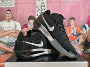 Black Nike basketball shoes with white Swoosh logos, shown from the side.