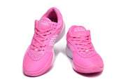 Pair of bright pink Nike sneakers shown from the front with white branding and textured soles.