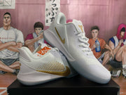 Angled view of the white and gold basketball sneakers showing the lace-up front, padded collar, side Swoosh, and outsole.