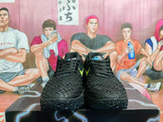 Front view of a pair of black basketball shoes with textured uppers and black laces.