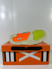Bottom view of the sneaker showing the cream outsole with orange and lime traction sections.