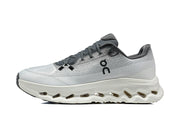 Side profile of a white and grey On running shoe with a sculpted sole.