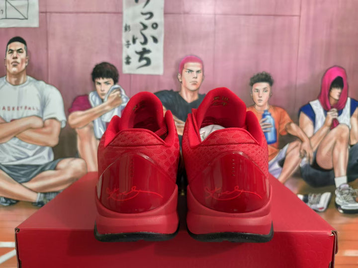 Rear view of red Nike basketball sneakers showing padded collars, translucent red heel panels, and black outsoles on a red box.