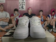 Front view of white low-top sneakers with white laces, perforated toe panels, and padded collars.